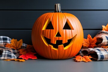 Close-up of a pumpkin on a porch decorated with autumn leaves and cozy plaid blankets