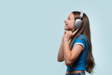 Young girl with headphones, listening to music and smiling.