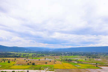 Fototapeta premium High angle view from the agricultural rice field, combined with the mountain view and clear sky, reflects the rich and loving nature of the world, Northern Thailand, Southeast Asia.