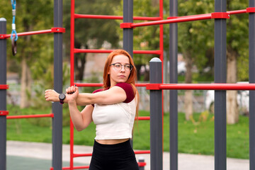 Fototapeta premium Woman performing arm stretches as part warm-up routine