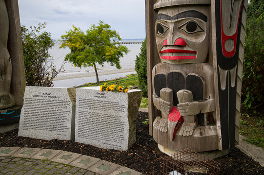 Coast Salish housepost and interpretive stones at Totem Park, White Rock, B.C., Canada. The repatriation of historic totem poles has become an important issue for First Nations communities.