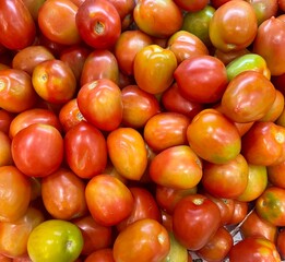 Photo of bunch of ripe tomatoes in a container