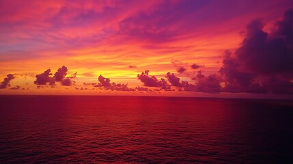 Obraz premium Dramatic Red Sunset Over Ocean with Clouds