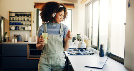 Smoothie, headphones and laptop with woman in kitchen for cooking blog, detox recipe and green...