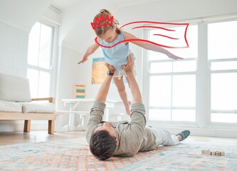 Airplane, superhero and father with child in home for playing, fun and bonding together. Happy, fantasy and dad lifting girl kid with animation cape and crown for flying imagination in living room. © peopleimages.com