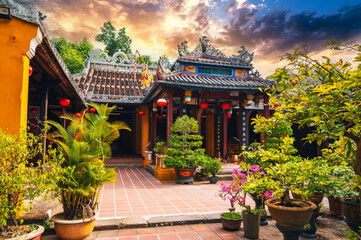 Beautiful ancient Asian Buddhist temple on pagoda in the old town in Hoi An in Vietnam in Asia at sunset in summer