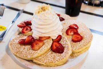 Fluffy Buttermilk Pancakes Topped with Fresh Strawberries and Whipped Cream