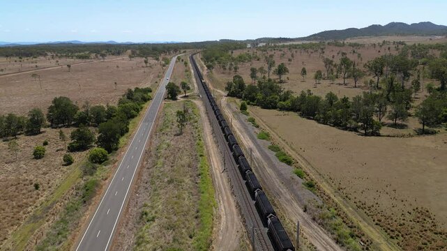 Forward moving aerial views over a coal train moving towards Gladstone, Central Queensland, Australia