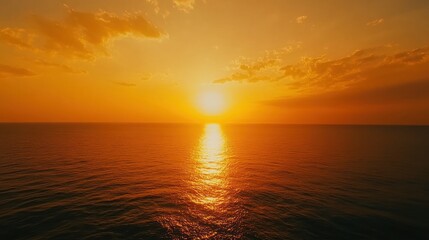Obraz premium A serene sunset over the ocean, reflecting warm hues on the water's surface.