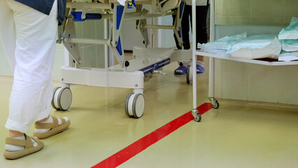 Fototapeta premium Two healthcare providers rush a gurney through a hospital operating room, emphasizing the critical nature of patient care in surgical settings