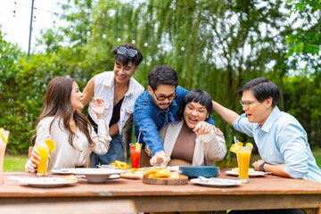 Group of Happy Asian millennial generation people friends enjoy and fun celebration reunion meeting outdoor dinner party with food and drink together in the garden at restaurant on holiday vacation.