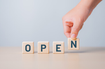 Hand-pick wooden cube blocks with OPEN words. A cafe, coffee shop, hotel, cafe restaurant, retail store, or online store is ready for service. The best service mind and business communication.