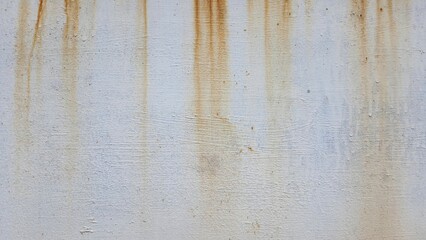 Texture of old rusty metal. Water stains left brown marks on the white wall, making it appear...