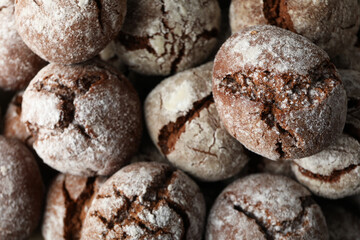 Appetizing crinkle cookies, on parchment, on a dark background.