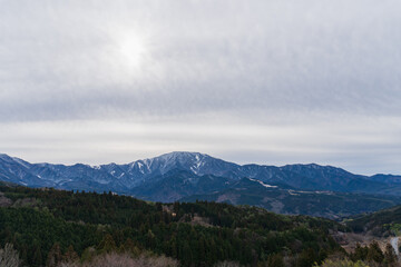 旧中山道の馬籠見晴台から見る木曽山脈と薄日が差す冬空／日本岐阜県