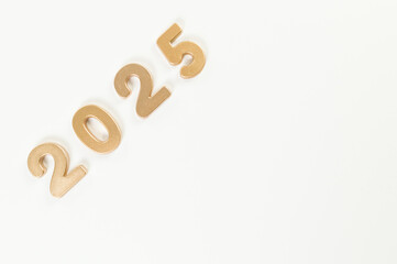 2025 Happy New Year. Top view of gold numbers on white background. Copy space, flat lay.
