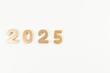2025 Happy New Year. Top view of gold numbers on white background. Copy space, flat lay.