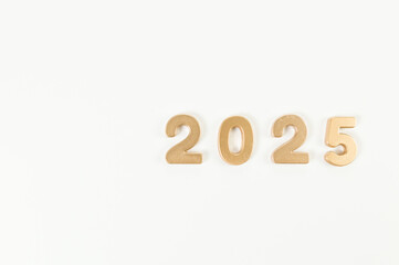 2025 Happy New Year. Top view of gold numbers on white background. Copy space, flat lay.