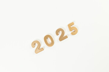 2025 Happy New Year. Top view of gold numbers on white background. Copy space, flat lay.