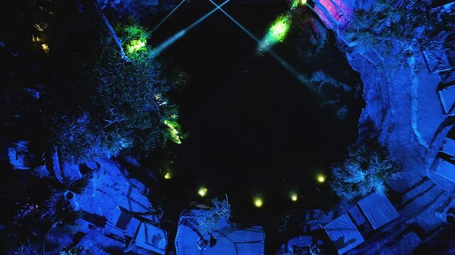 Birds eye drone shot rising above pond in middle of colorful lights, in Mexico