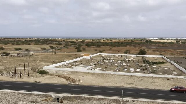 Aerial Panning View of Desert Cemetery in Rabil, Cape Verde with roundabout street and buildings