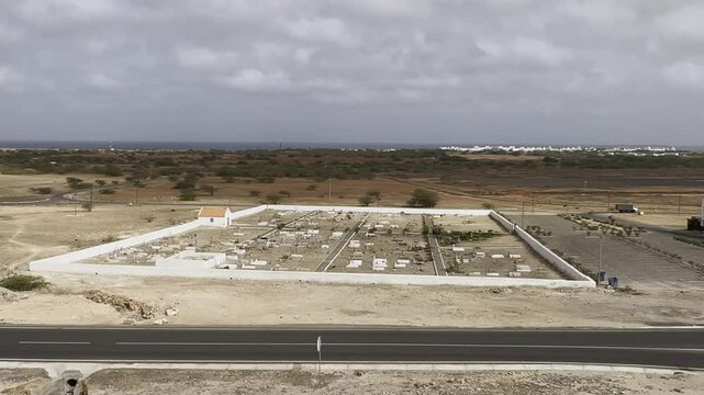 Aerial View of Desert Cemetery in Rabil, Cape Verde, Surrounded by Barren Landscape and asphalted road