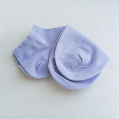 A new pair of blue socks lies on a white table. Thin, short socks. Advertising background, space for text.