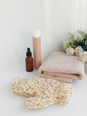 Shampoo bottle, serum, towel and washcloth on white background. Bath set. Cosmetics for care. Background