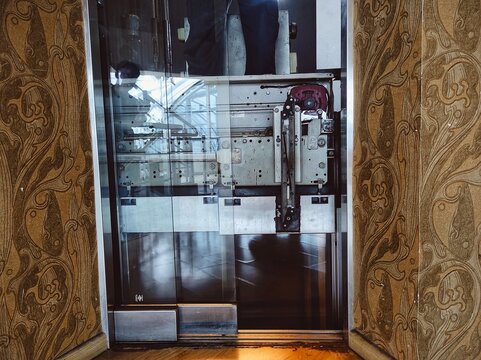 Specialist fixing or adjusting lift mechanism in elevator shaft. Regular repair, service and maintenance of elevators