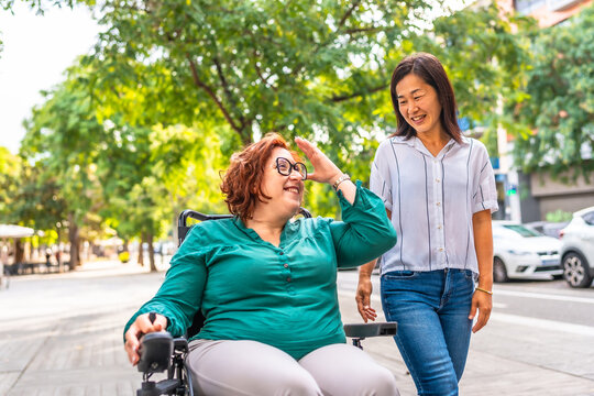 Woman with disability talking with chinese friends while walking outdoors