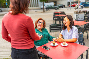 Disabled woman and caregiver paying with credit card at cafeteria