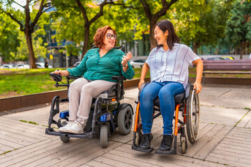 Happy women friends with disability talking in a park
