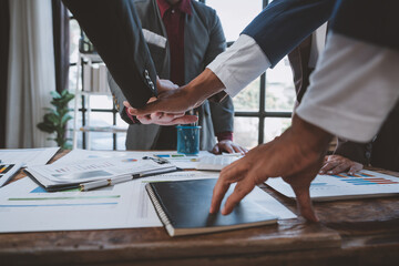 Team of business people or partners in Asian team, business people hands clenching fists after completing an agreement, working together in the office of colleagues teamwork concept.