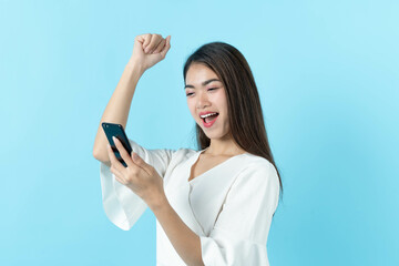 Young woman looking at mobile screen and feeling overjoyed on the luck on the gift.