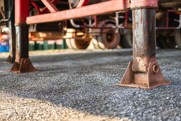 Close-up at cargo truck or trailer 's landing support legs are extended on ground, It using for support the load when the truck is parking. Transportation equipment object, selective focus.