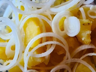 evocative image of a home container with boiled potatoes and 
chopped onions ready to be seasoned and eaten