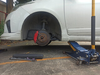 Fototapeta premium Car mechanic changing a disc brake on a car in a garage.
