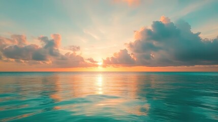 Obraz premium A serene ocean sunset with colorful clouds reflecting on calm waters.