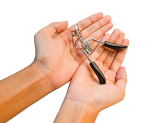 A woman's hand is holding an eyelash curler in her hand, isolated on a white background and taken from a close-up.