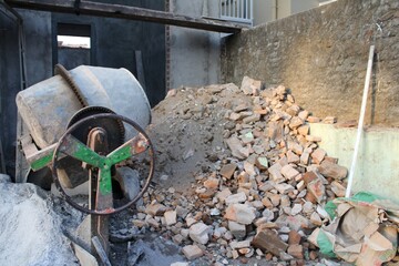 Concrete Mixer and Construction Site with Piles of Brick and Debris, Industrial Building Project in...