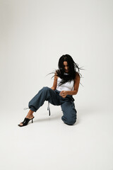 African American young woman shaking with long dark braids looking away. Vertical.