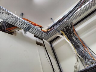 Fototapeta premium Organized Complexity of Cable Management: A Network of Wires Symbolizing Connectivity and Infrastructure in Industrial Settings