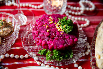 Festive table with Rosolli salad - traditional Finnish Christmas meal made of cooked, diced beetroot, carrot and potato. Celebration delicacies on Christmas table in Finland and Scandinavia