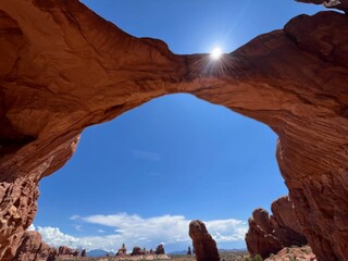 Natural rock arch under a bright blue sky in Utah.