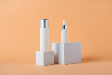 Plastic white tube for cream or lotion. Skin care or sunscreen cosmetic with stylish props on cream background.