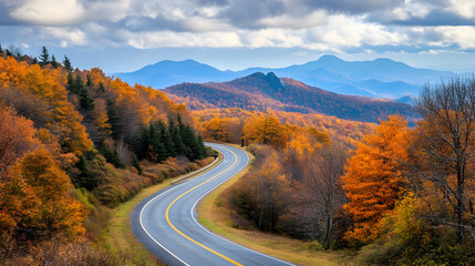 Winding asphalt road through vibrant fall foliage in the mountains.
