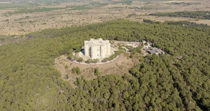 Aerial view of Castel del Monte. It is a castle situated on a hill near Andria in the Apulia region, Italy. A medieval fortress famous for its bold octagonal plan. There is a dense forest around it.