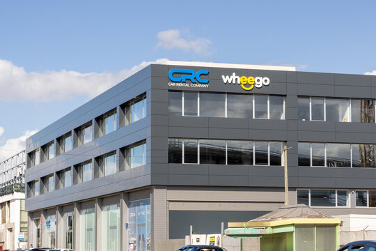 Wheego and crc car rental company building displaying their logos on a sunny day