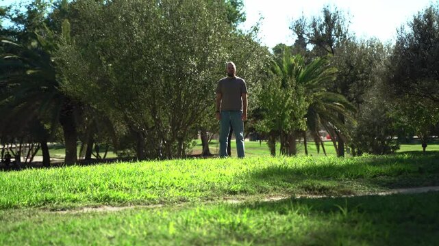 Man playing fetch Oporto with his happy pet dog golden retriever outside in public park during summer. Owner takes care about his pet. Mental health of domestic animals,