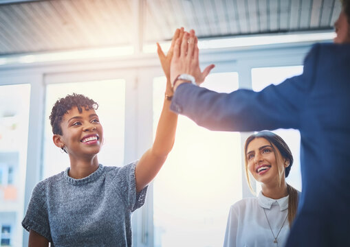 Woman, high five and happy at meeting in office for motivation, success or performance with group at company. Person, team and cheers for goal, profit and support with diversity at insurance agency